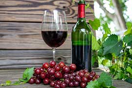 muscadine wine in glass and bottle and grapes