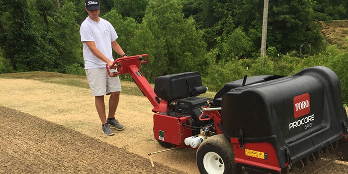 Student using equipment to manage turf